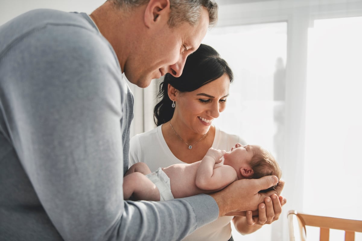 A family couple with cute newborn baby indoors